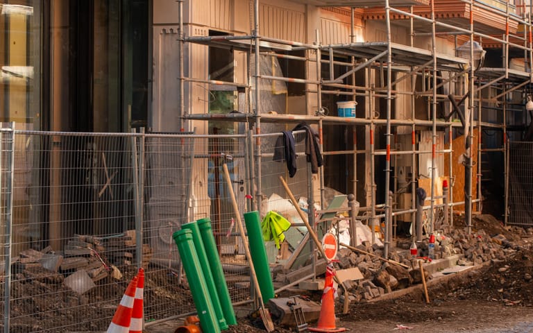 Building site with scaffolding and barriers, illustrative