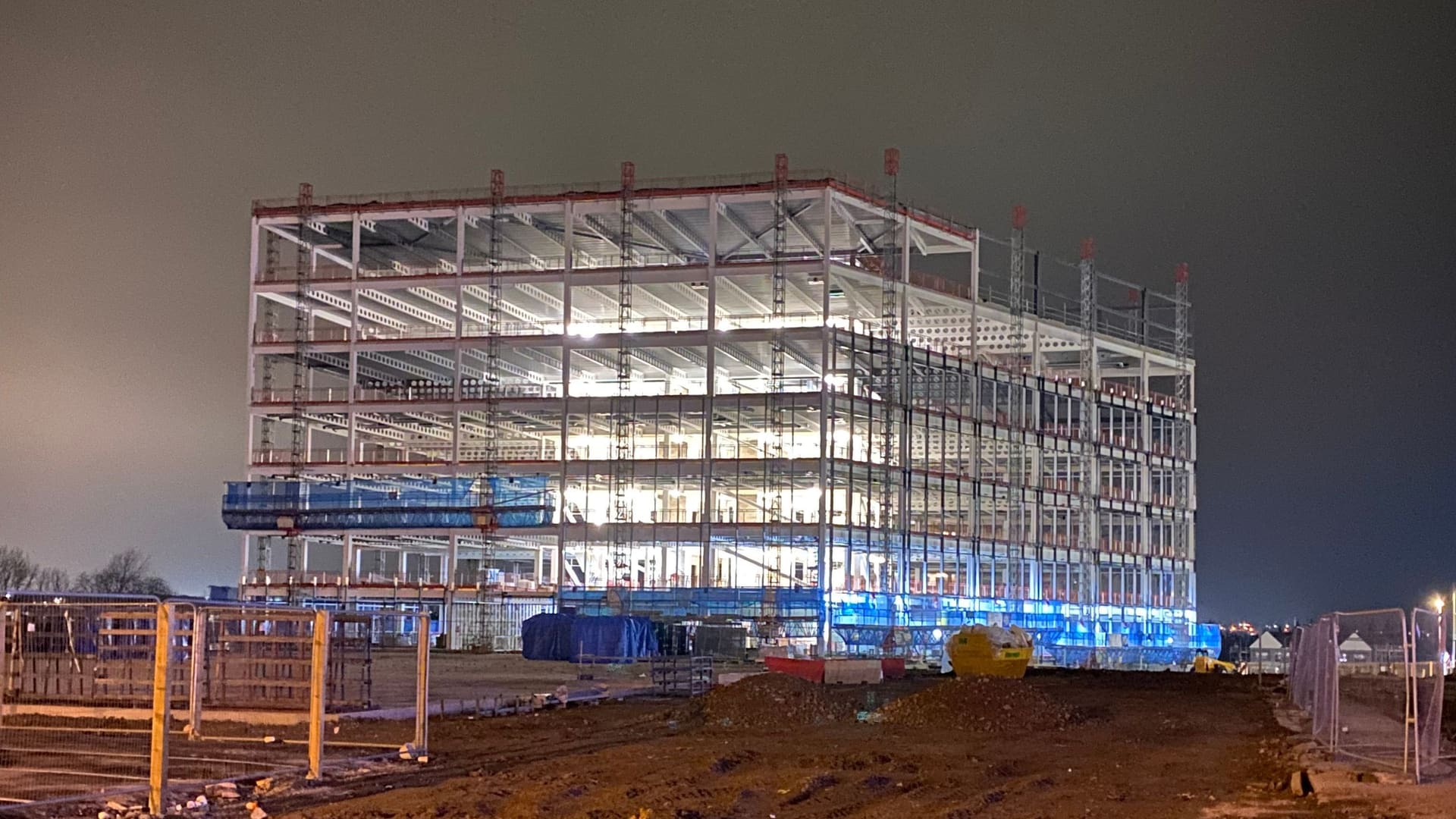 Steel frame rising on a cleared site, illustrative